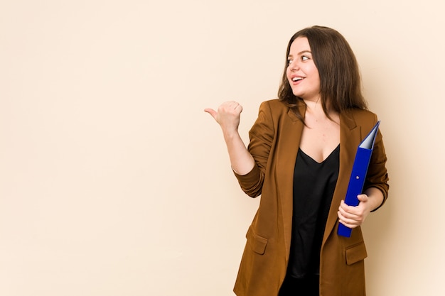 Joven mujer de negocios con archivos de puntos con el dedo pulgar, riendo y sin preocupaciones.