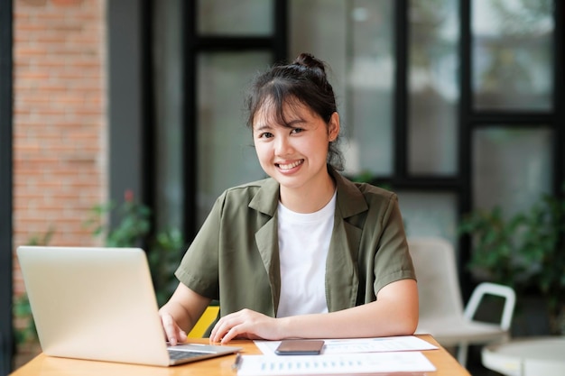 Joven mujer de negocios asiática o estudiante que trabaja en línea en una computadora portátil
