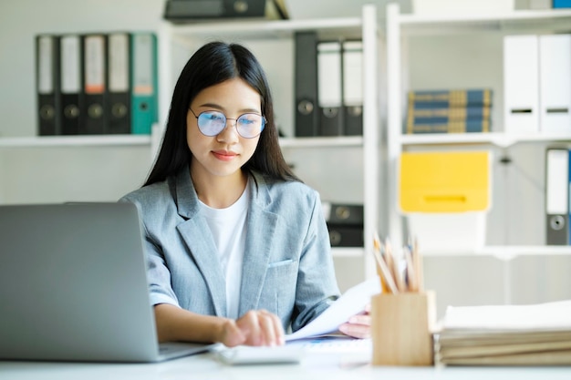 Joven mujer de negocios asiática o estudiante que trabaja en línea en una computadora portátil