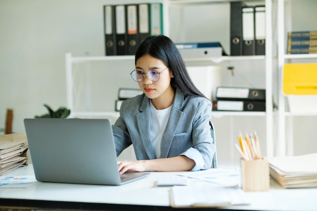 Joven mujer de negocios asiática o estudiante que trabaja en línea en una computadora portátil