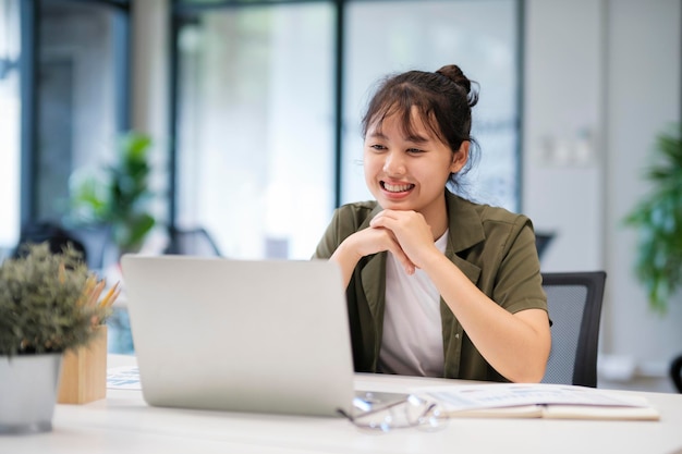 Joven mujer de negocios asiática o estudiante que trabaja en línea en una computadora portátil