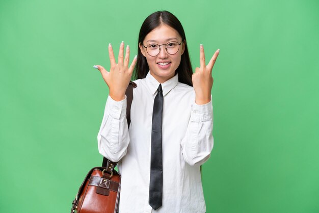 Joven mujer de negocios asiática sobre un fondo aislado contando siete con los dedos