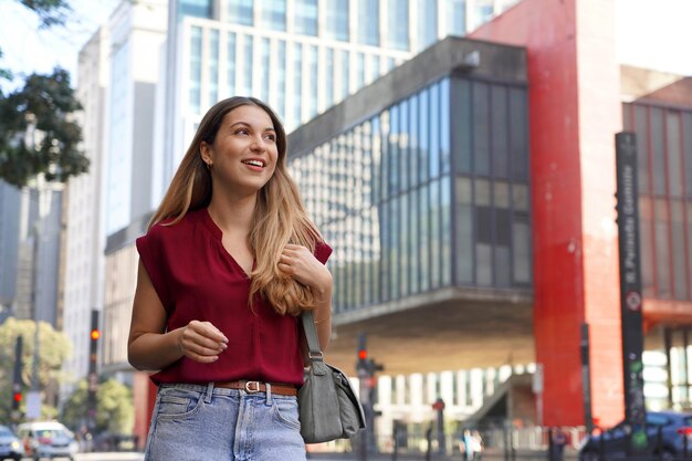 Foto joven mujer de negocios brasileña caminando por la avenida paulista sao paulo brasil