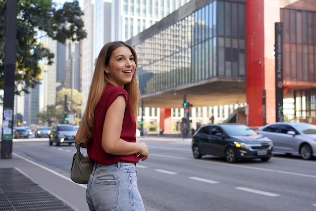 Joven mujer de negocios brasileña esperando un taxi o un uber en la avenida Paulista de Sao Paulo, Brasil