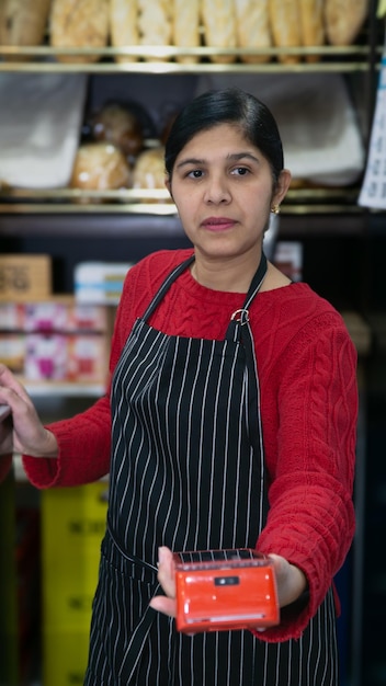 joven mujer de negocios cargando al cliente en la cafetería en primer plano