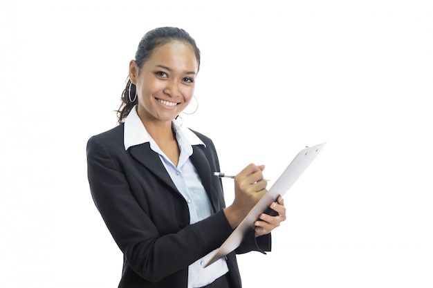 Joven mujer de negocios escribiendo informe mientras está de pie y sonriendo