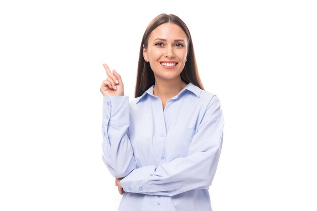 Foto una joven mujer de negocios europea exitosa con cabello largo y negro lleva una blusa azul.