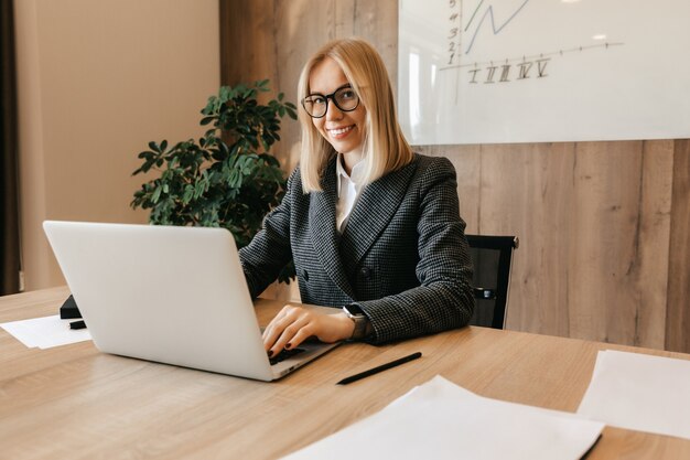 Una joven mujer de negocios exitosa se sienta en un lugar de trabajo en su oficina como directora de la empresa. Trabajador del centro de negocios.