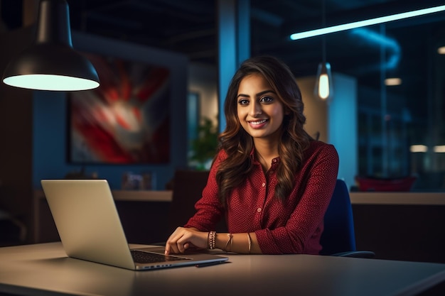 Joven mujer de negocios feliz usando computadora en una oficina moderna con colegas elegante y hermosa gerente