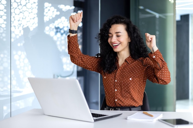 Joven mujer de negocios hispana obtuvo un buen resultado de trabajo mujer de negocios está feliz y celebrando la victoria