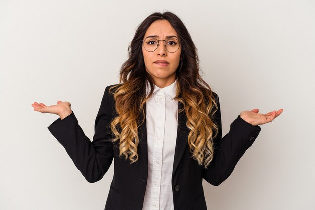 Foto joven mujer de negocios mexicana aislada sobre fondo blanco confundida y dudosa encogiéndose de hombros para mantener un espacio de copia.