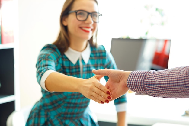 Foto joven mujer de negocios moderna con el brazo extendido para estrechar la mano