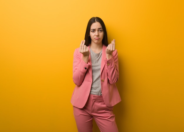 Joven mujer de negocios moderna haciendo un gesto de necesidad