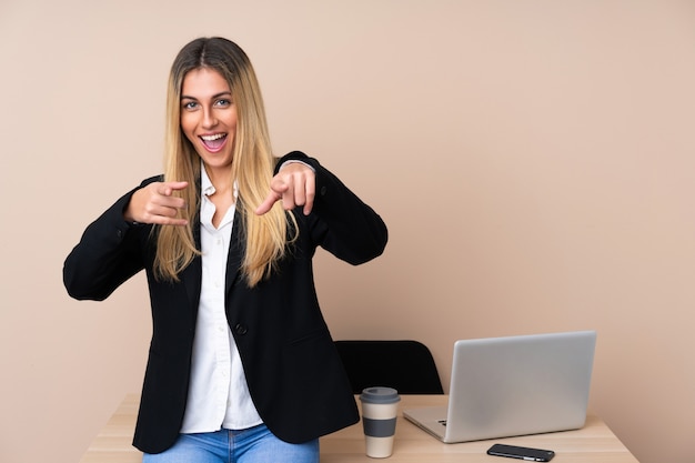 Joven mujer de negocios en una oficina señala con el dedo