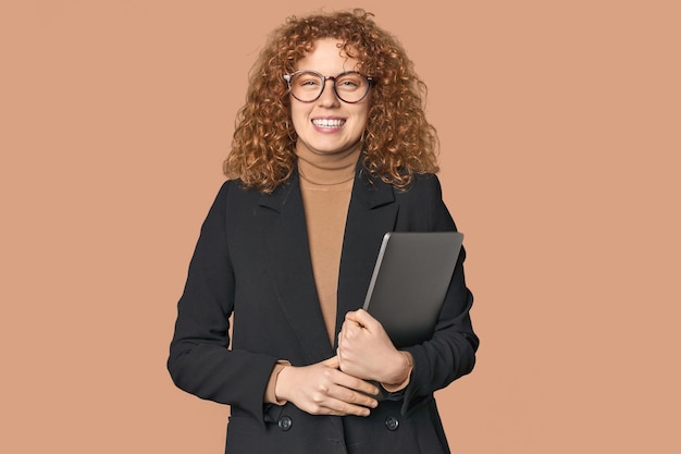 Joven mujer de negocios pelirroja blanca con una computadora portátil feliz