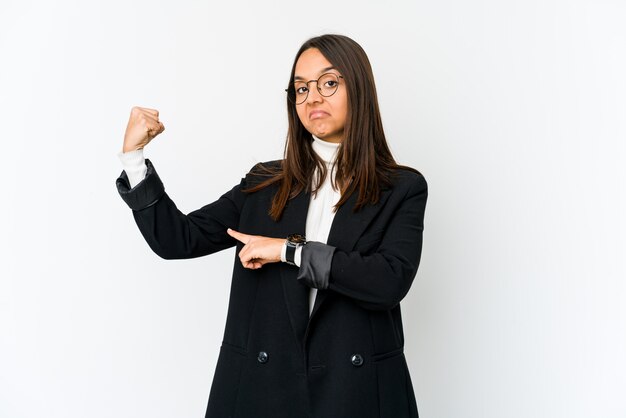 Joven mujer de negocios de raza mixta aislada en blanco que muestra gesto de fuerza con los brazos, símbolo del poder femenino