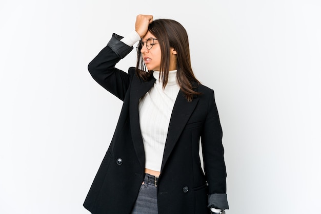 Joven mujer de negocios de raza mixta aislada olvidando algo, golpeándose la frente con la palma y cerrando los ojos.