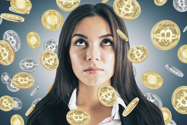 Foto joven mujer de negocios reflexiva con bitcoin lluvia dinero y concepto de comercio