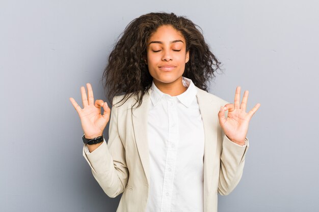 Joven mujer de negocios se relaja después de un duro día de trabajo, ella está realizando yoga