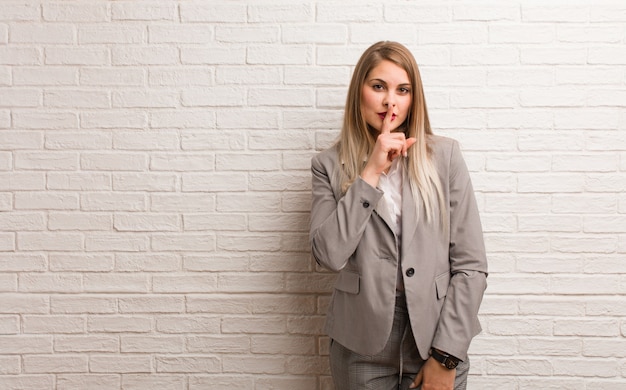 Joven mujer de negocios rusa manteniendo un secreto o pidiendo silencio