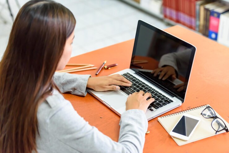 Foto joven mujer de negocios trabajando en una computadora portátil en un escritorio en la oficina