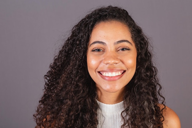 Joven mujer negra brasileña foto de primer plano sonriendo mirando a la cámara sonrisa de dientes blancos