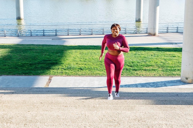 joven, mujer negra, ejercitar, correr, arriba, pasos