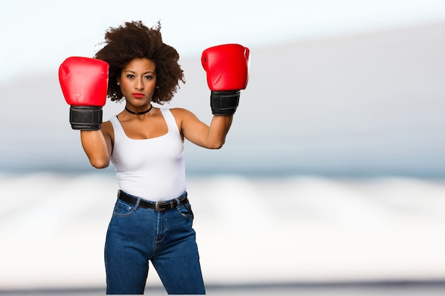 joven mujer negra con guantes de boxeo