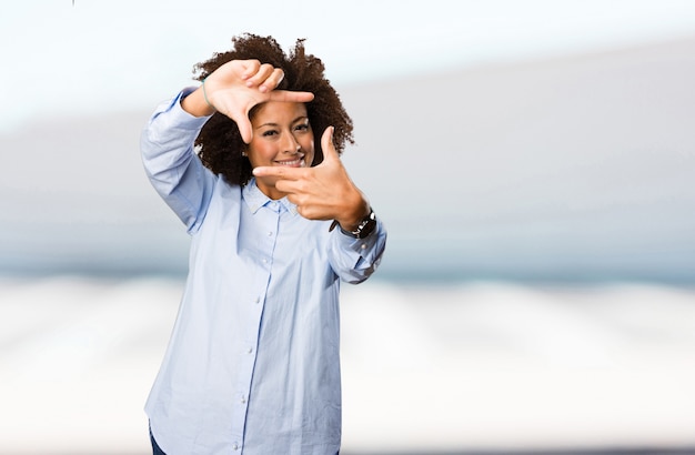 Foto joven mujer negra haciendo gesto de marco