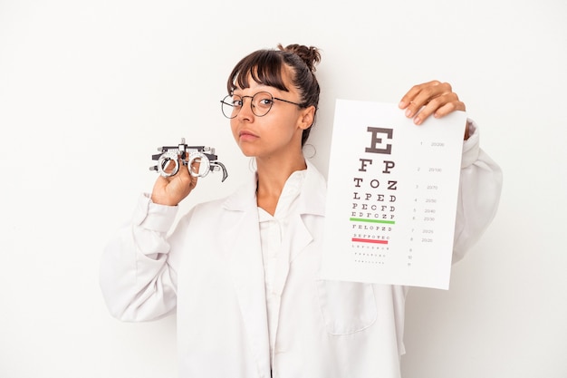 Joven mujer óptica de raza mixta haciendo una prueba aislada sobre fondo blanco.