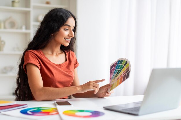 Joven mujer oriental diseñadora gráfica independiente trabajando con una computadora portátil