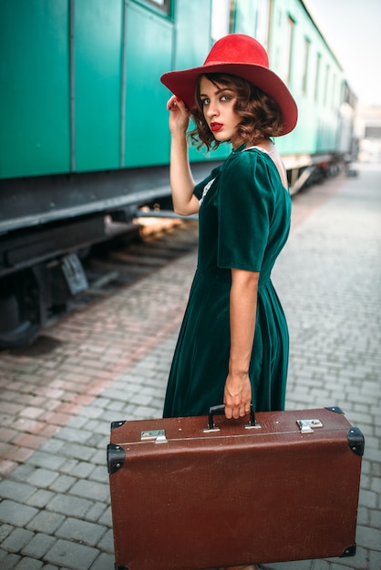 Joven mujer pasada de moda viaja en tren retro