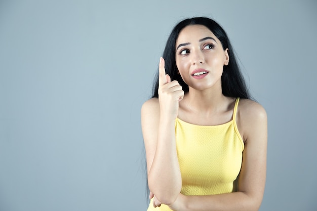 La joven mujer pensante en gris