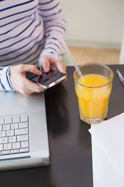 Joven mujer ponerse al día con el trabajo en el café