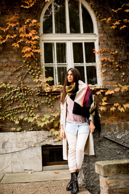 Joven mujer posando afuera en el día de otoño