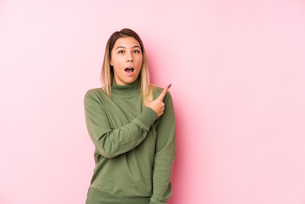 Joven mujer posando apuntando hacia el lado