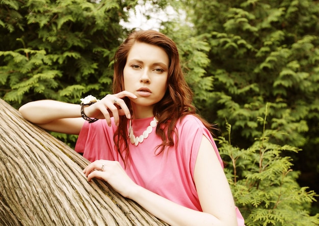 Joven mujer posando en un árbol