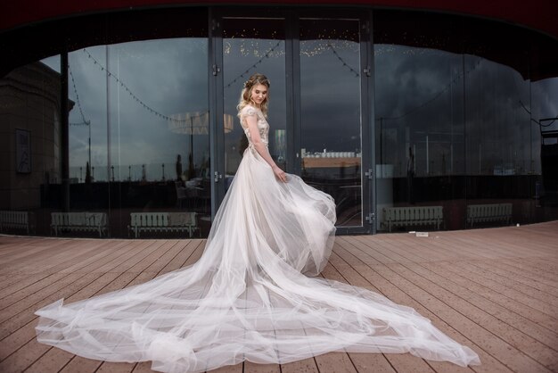 Joven mujer posando en un vestido de novia blanco