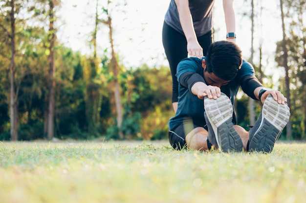 Joven y mujer que se extiende en el parque