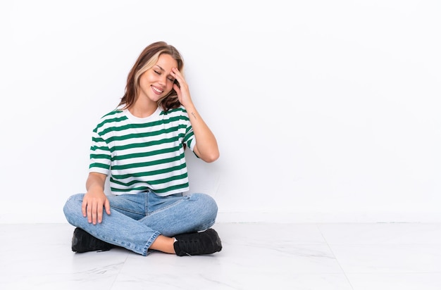 Foto joven mujer de raza mixta bebiendo una bebida fresca aislada de fondo azul haciendo un gesto de parada y decepcionada