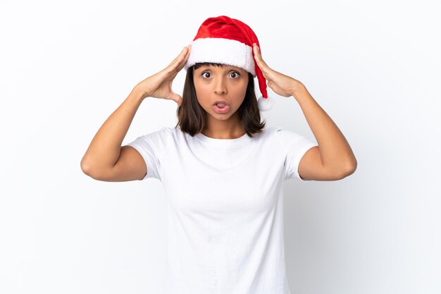 Joven mujer de raza mixta celebrando la Navidad aislado sobre fondo blanco con expresión de sorpresa