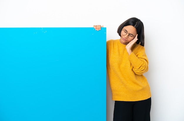 Joven mujer de raza mixta con un gran cartel azul aislado sobre fondo blanco con dolor de cabeza