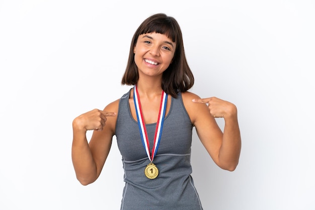 Joven mujer de raza mixta con medallas aislado sobre fondo blanco orgulloso y satisfecho de sí mismo