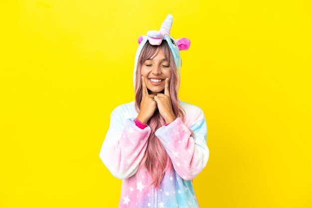 Joven mujer de raza mixta vistiendo un pijama de unicornio aislado sobre fondo blanco sonriendo con una expresión feliz y agradable