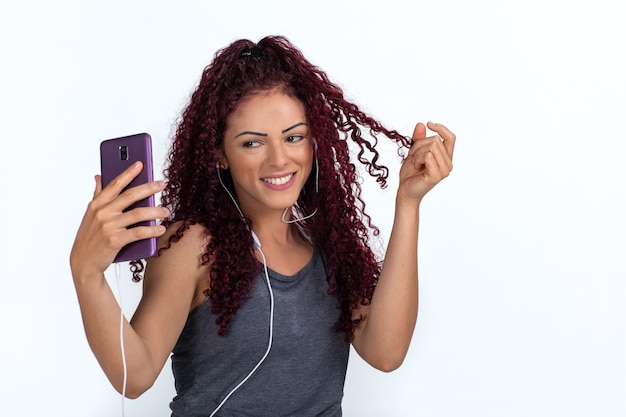 Foto joven mujer rizada en ropa casual tomando un selfie