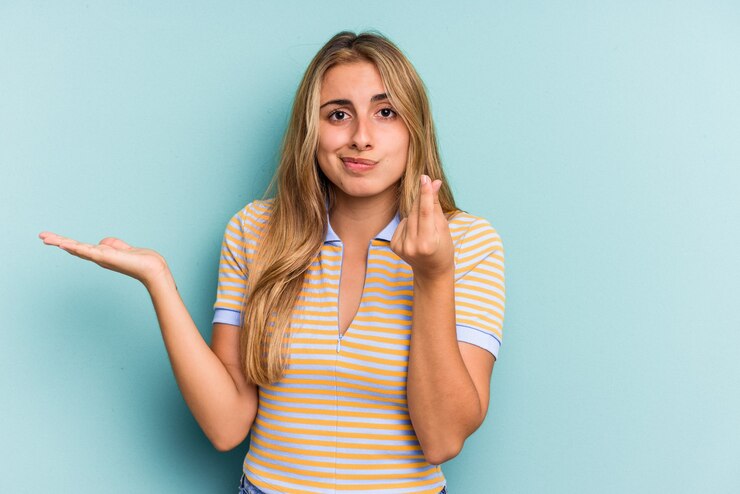 Foto joven mujer rubia caucásica aislada sobre fondo azul mostrando que no tiene dinero.