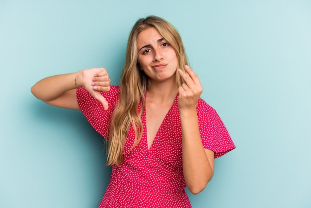 Joven mujer rubia caucásica aislada sobre fondo azul mostrando que no tiene dinero.