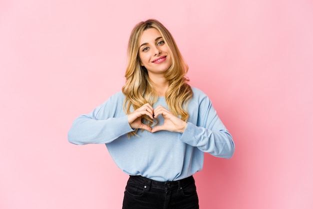 Foto joven mujer rubia caucásica divertida y amigable sacando la lengua.