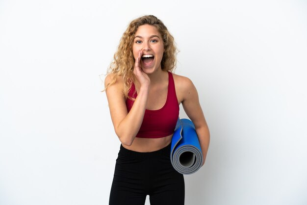 Joven mujer rubia de deporte yendo a clases de yoga