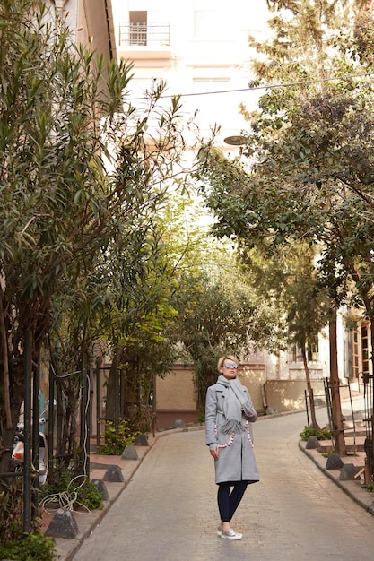 Joven mujer rubia con gafas de sol en la calle